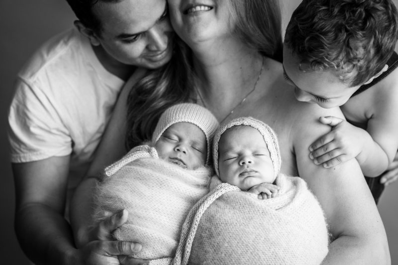 twin newborn posing with family