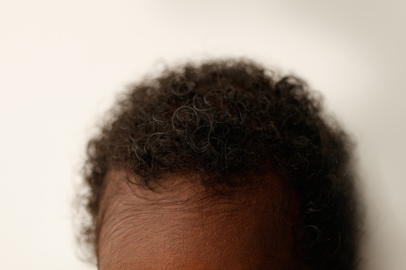 Newborn Photographer, a baby's full head of hair curls into an afro