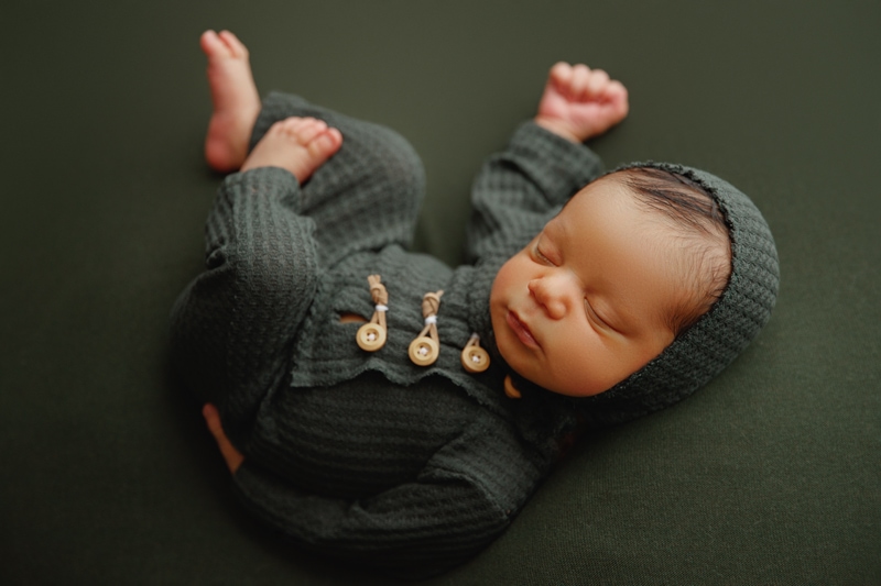Newborn Photographer, a baby boy wears a knit onesie and takes a nap all sprawled out