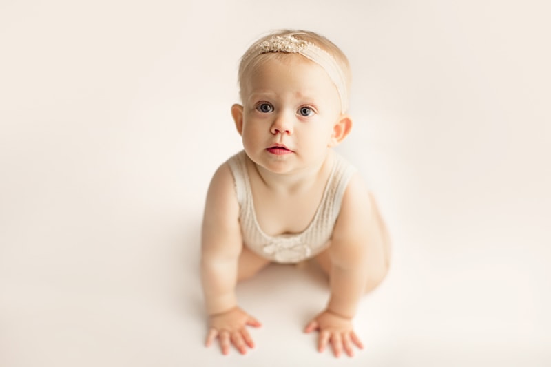 Baby Photographer, a little baby girl crawls wearing a onesie