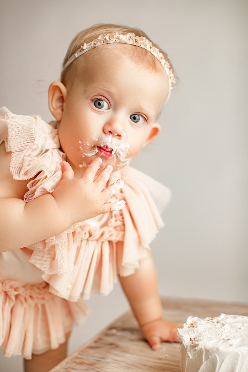 Baby Photographer, a baby girl eats her milestone cake