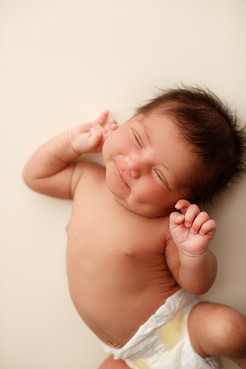 Newborn Photographer, a little baby stretches during a nap
