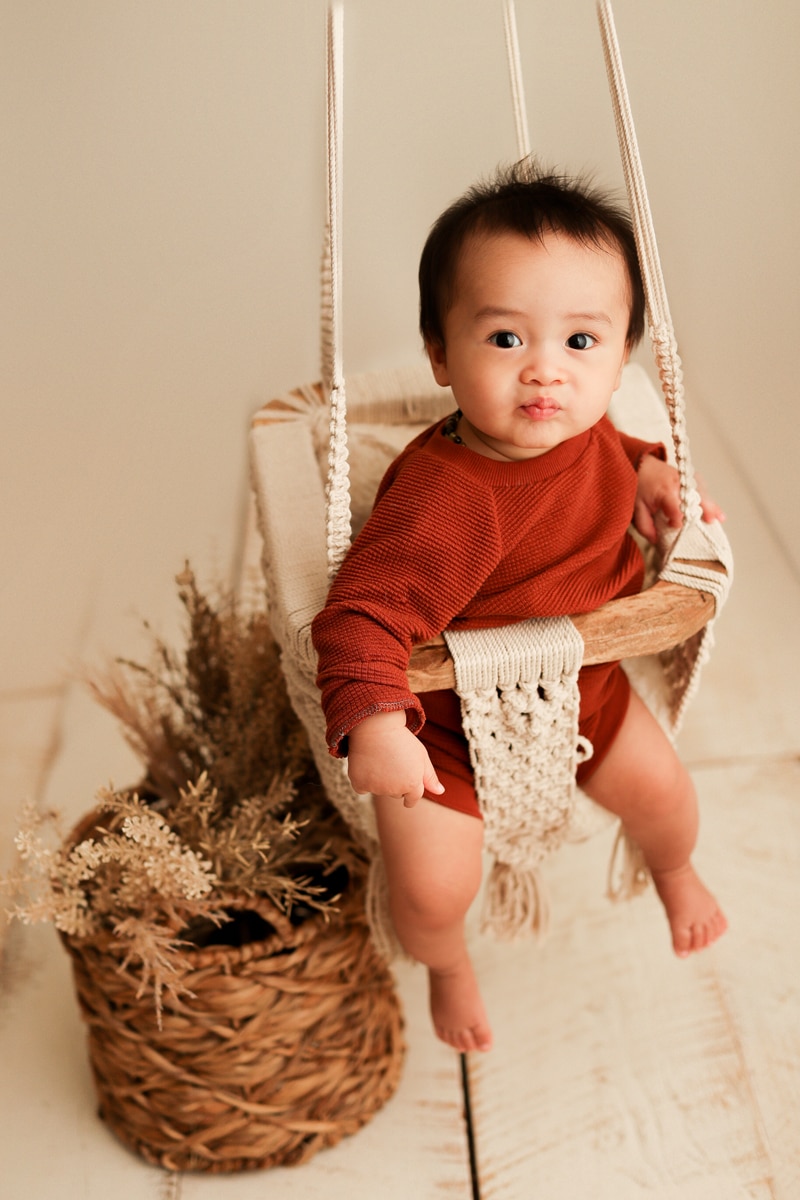 Baby Photographer, baby sits in macrame swing