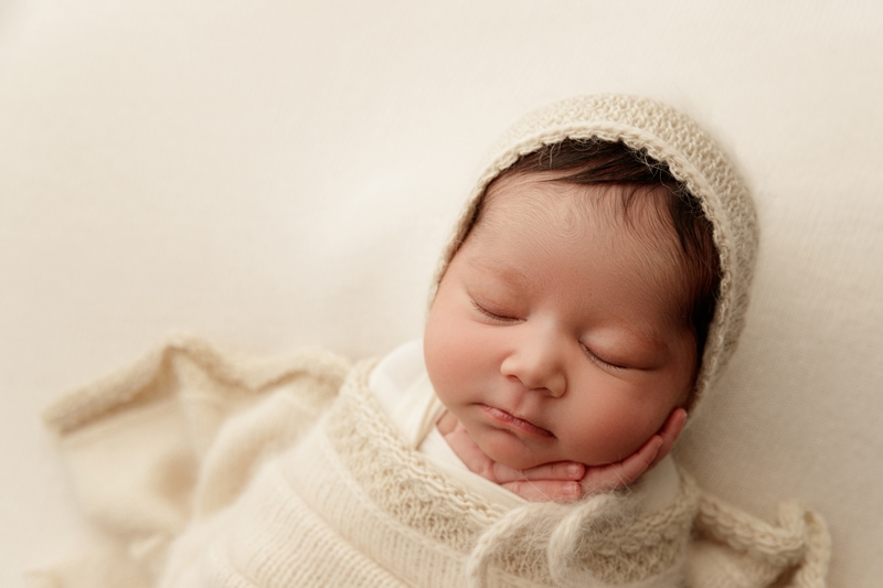 Newborn Photographer, Baby is asleep wrapped in knit blanket