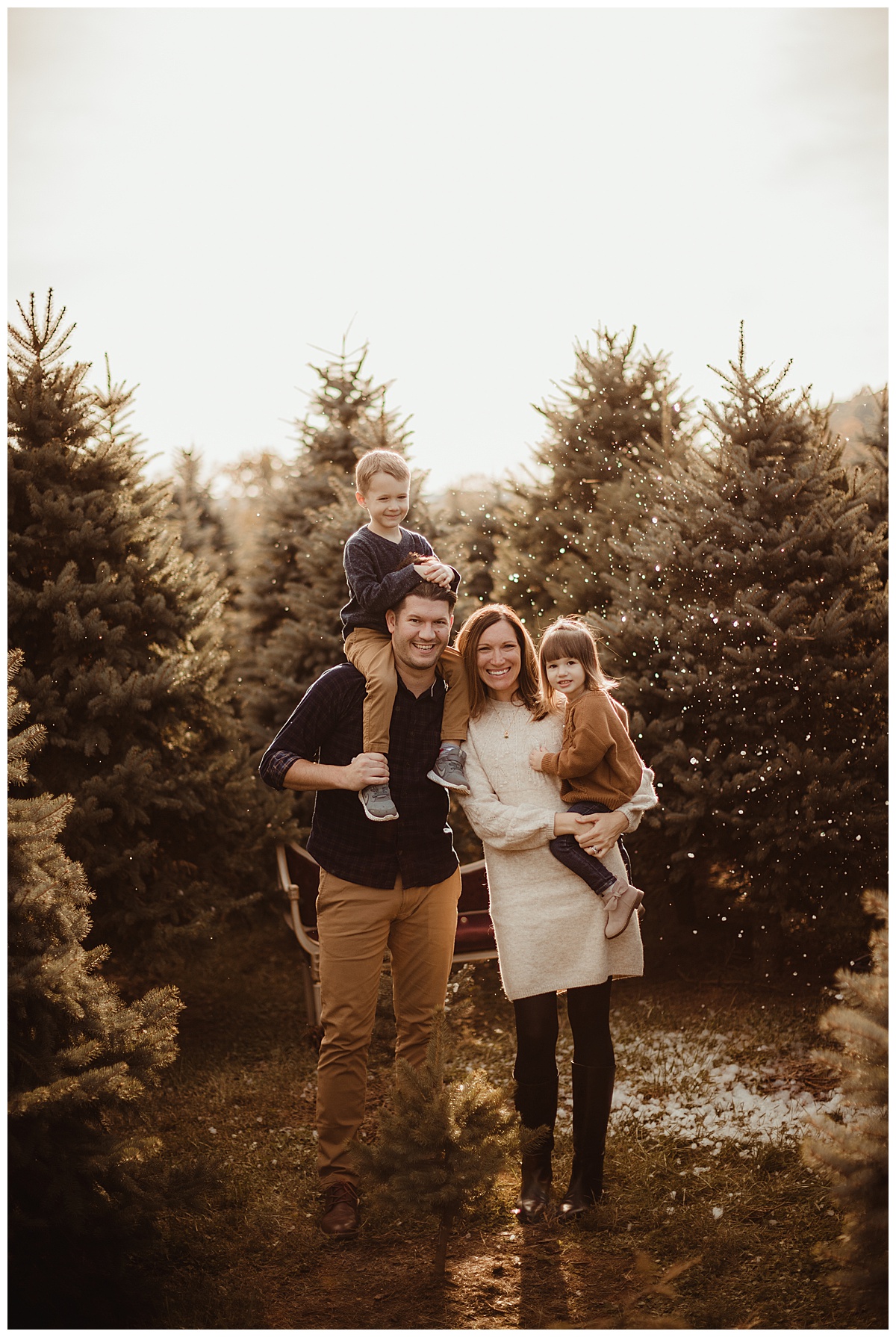 Family standing in front of trees by Norma Fayak Photography