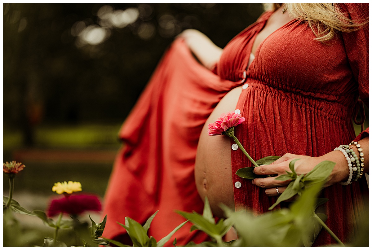 Flower near pregnant belly by Norma Fayak Photography