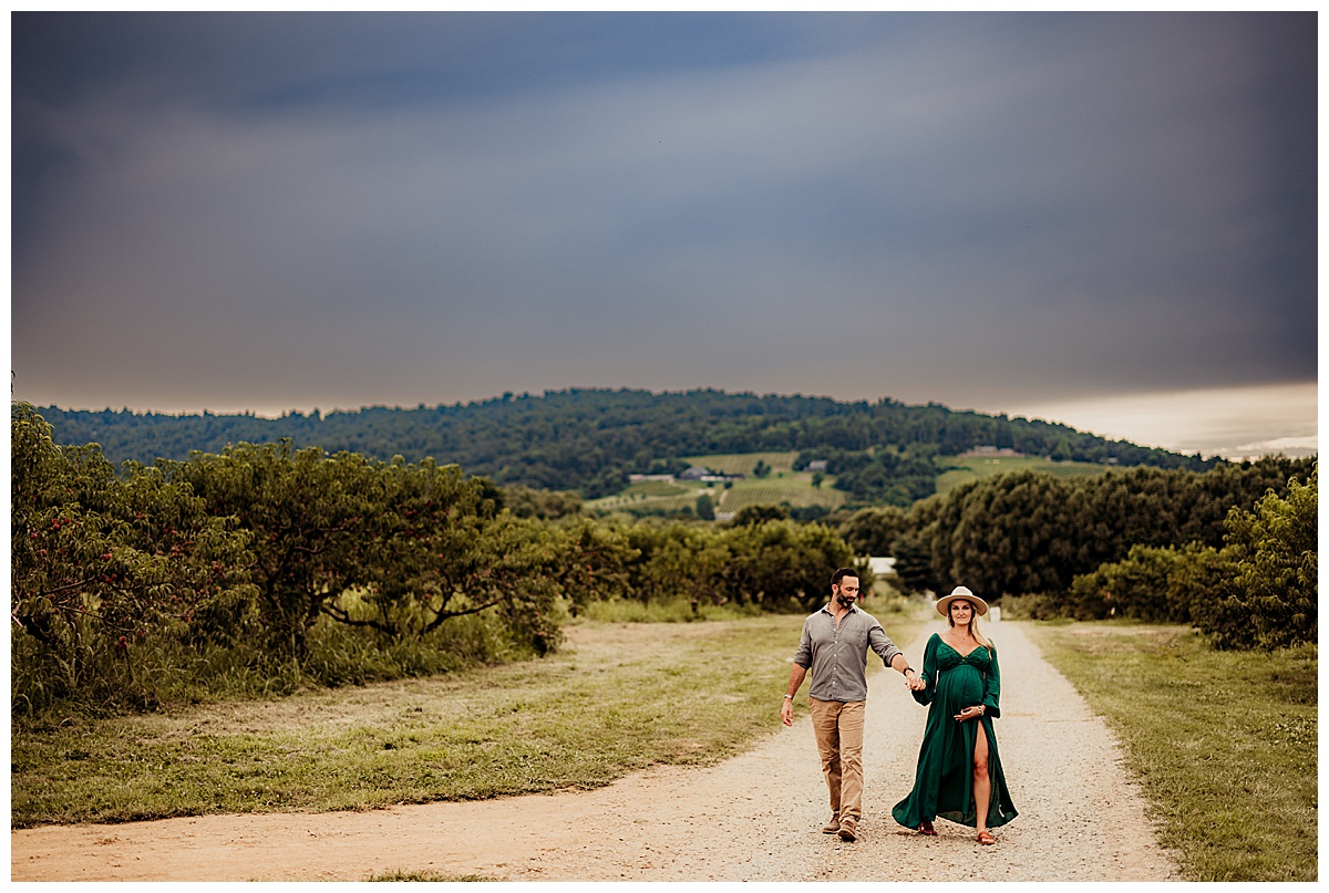 Couple walks down road during Great County Farms Maternity Session
