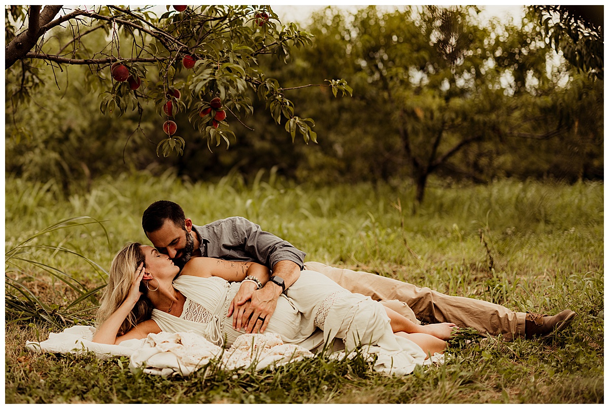 Man and woman laying down in field by Washington DC Maternity Photographer