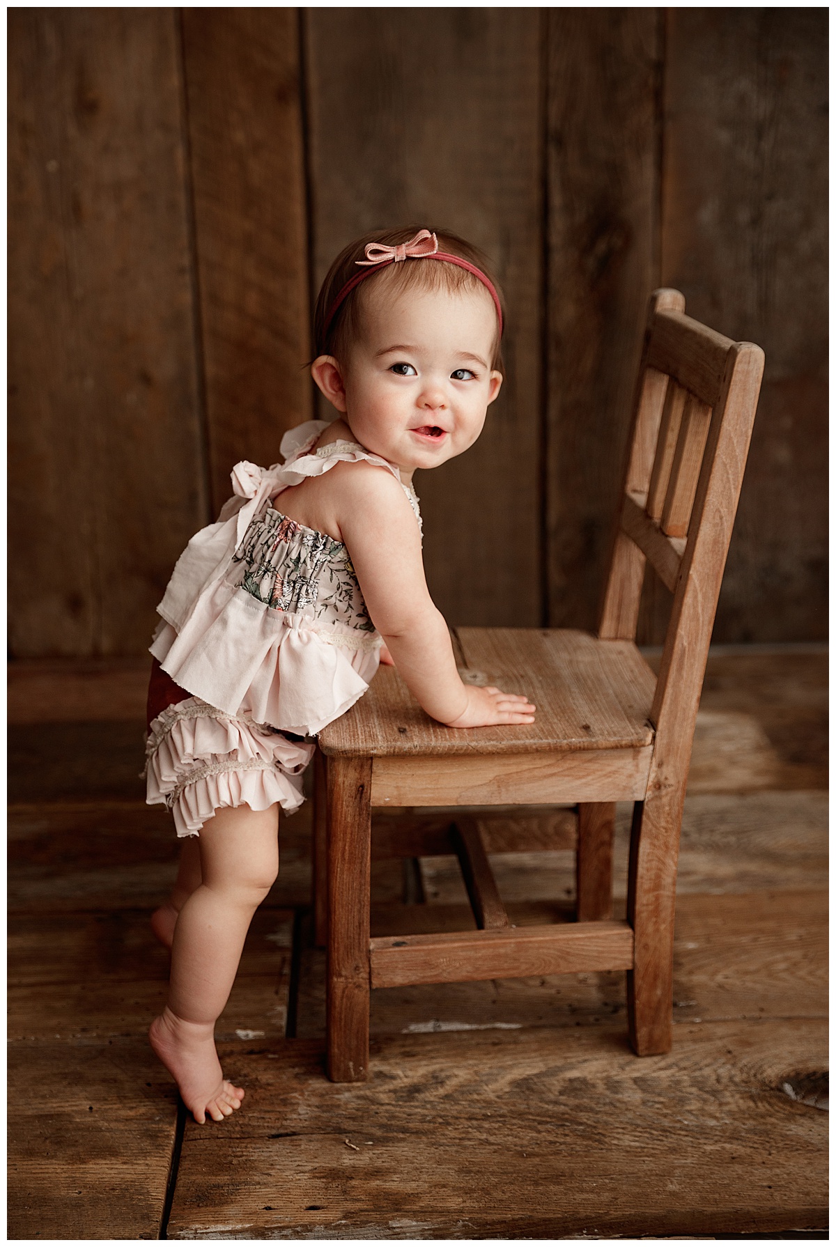 Baby leans against chair for Norma Fayak Photography
