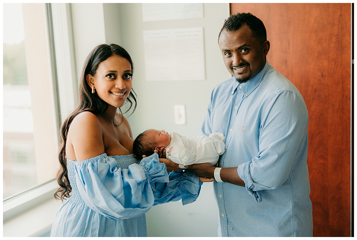 Happy parents holding baby for Washington DC Newborn Photographer