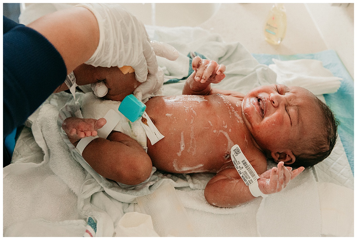 Infant being scrubbed by nurse for Washington DC Newborn Photographer