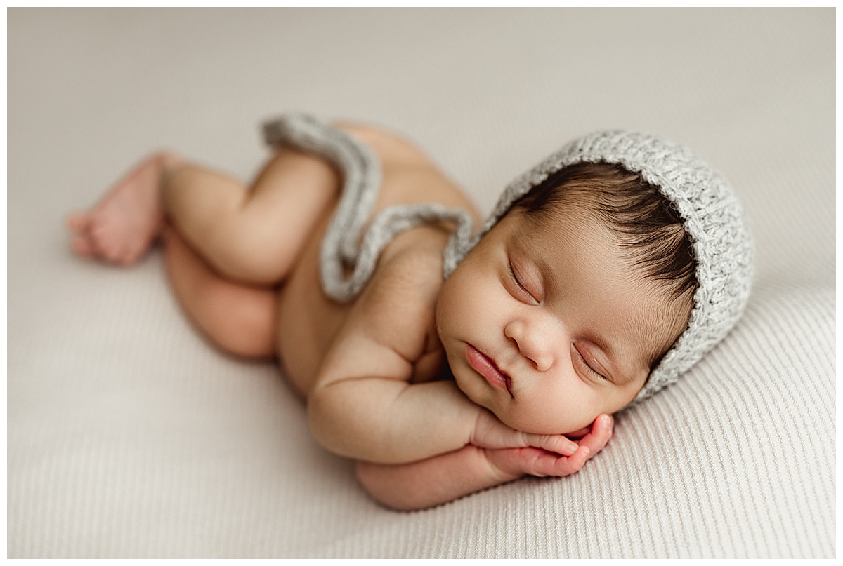 Young baby cuddled with hand for Fine Art Posed Session