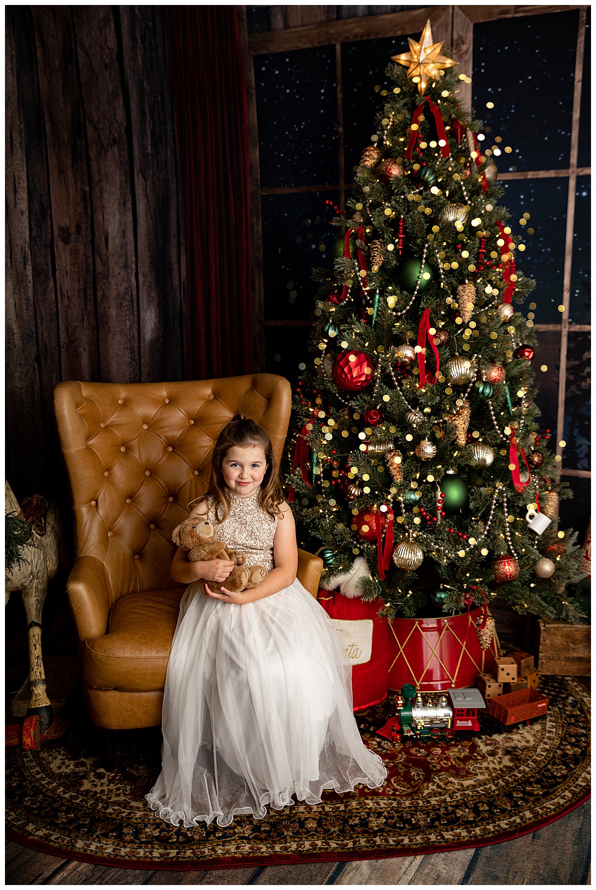 Child sits by Christmas tree for Washington DC Family Photographer