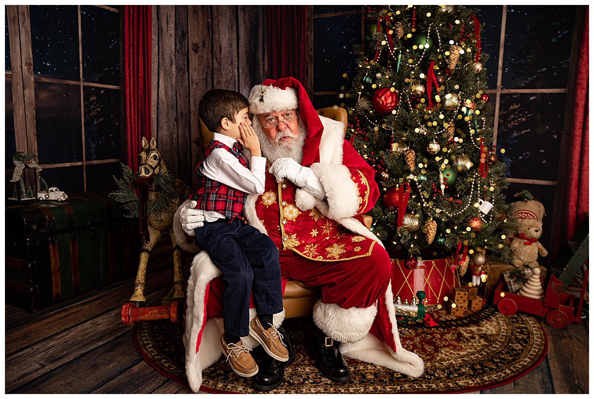 Young boy whispering while Meeting Santa