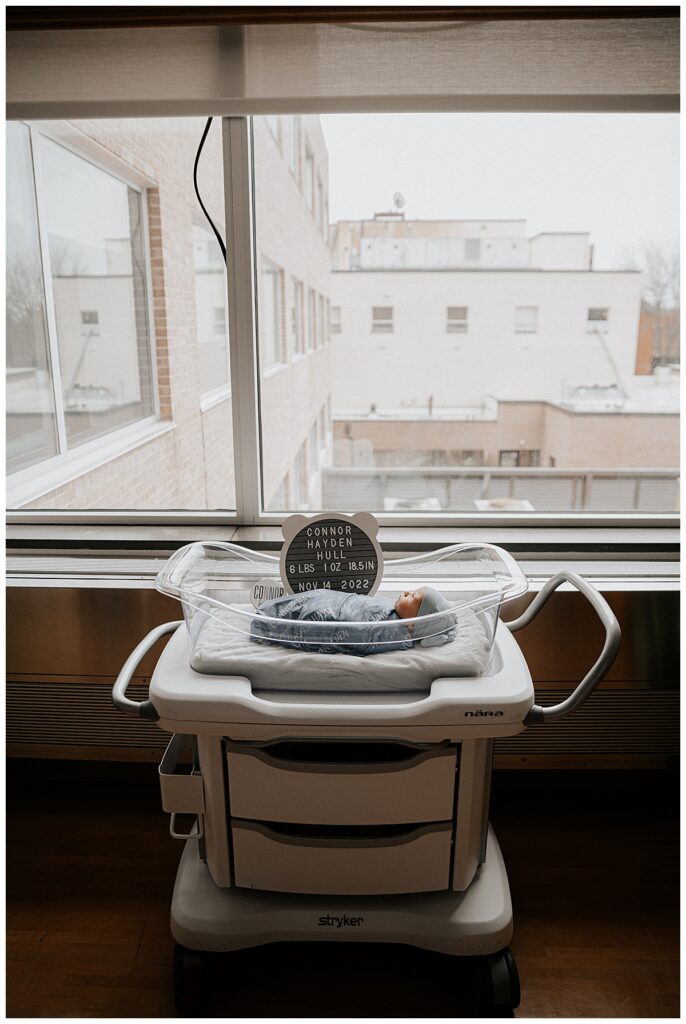 Baby boy in bassinet by window for The Fresh 48 Experience