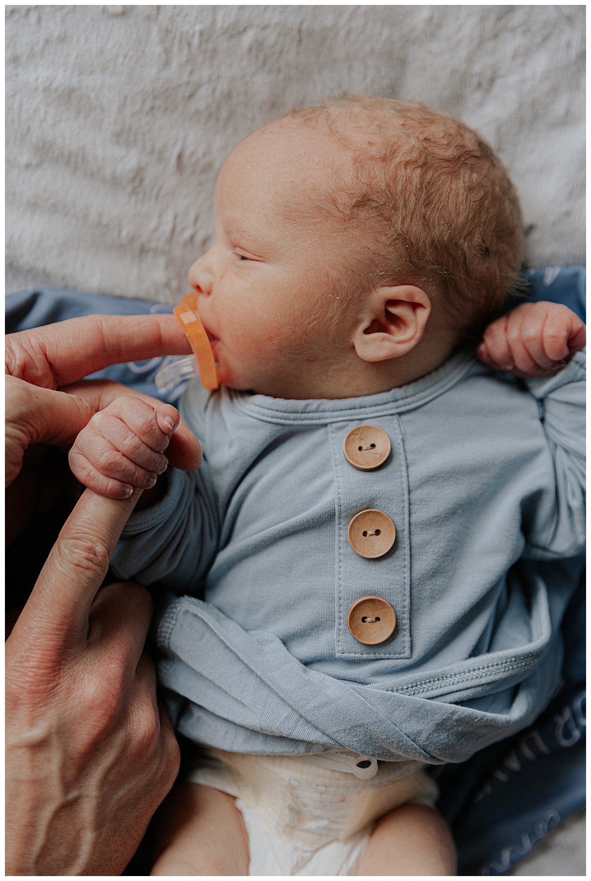 infant sucks on pacifier for Washington DC Newborn Photographer