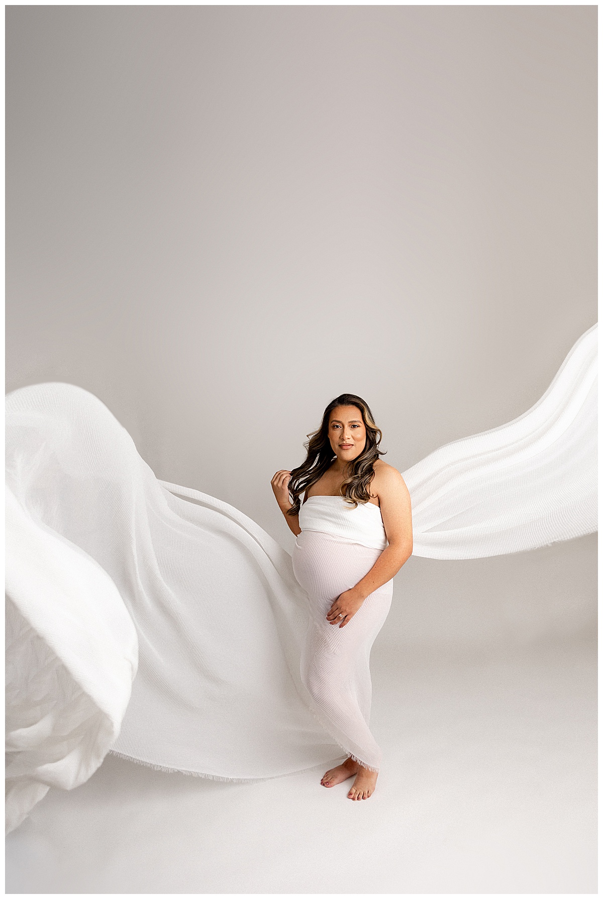 Mother to be in white gown for Norma Fayak Photography