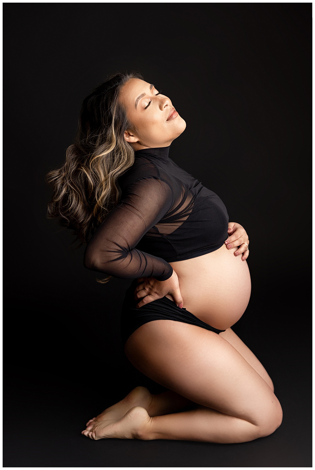 Mom kneels and holds pregnant belly for Norma Fayak Photography