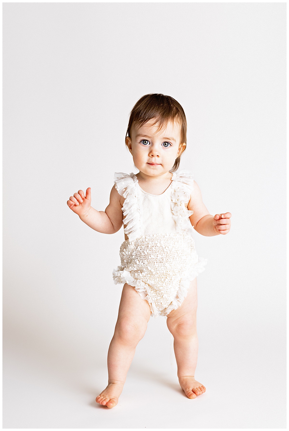 Infant standing up in romper for Virginia Newborn Photographer