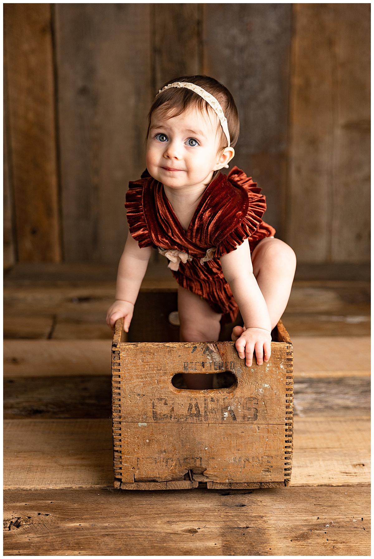 Baby girl sits in wood box for Norma Fayak Photography