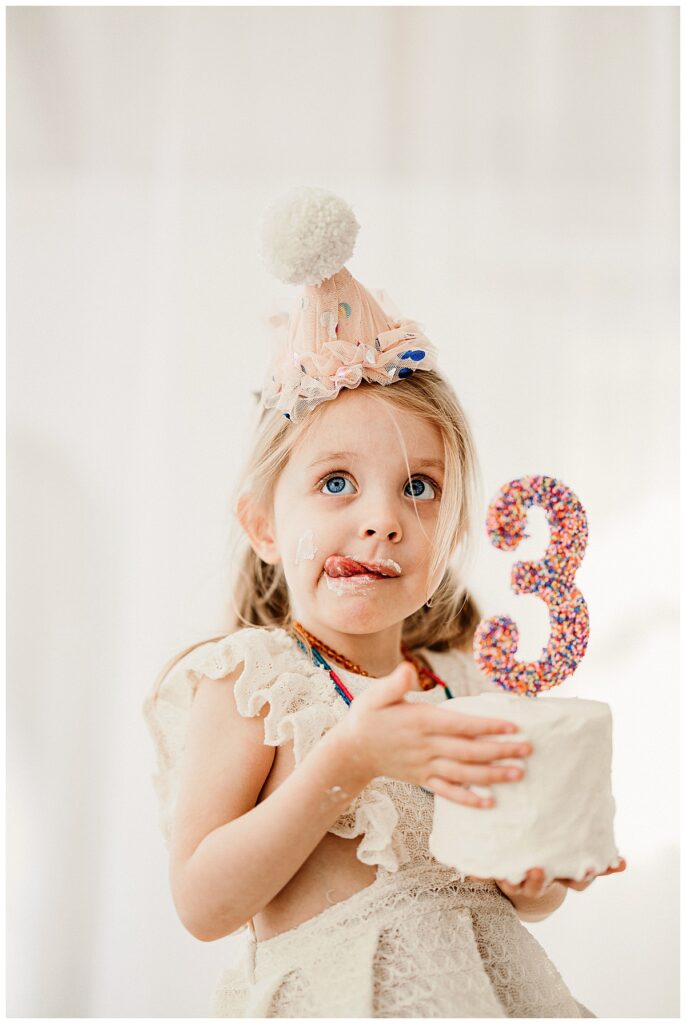 Little girl licks the icing for her Birthday Session In The Studio