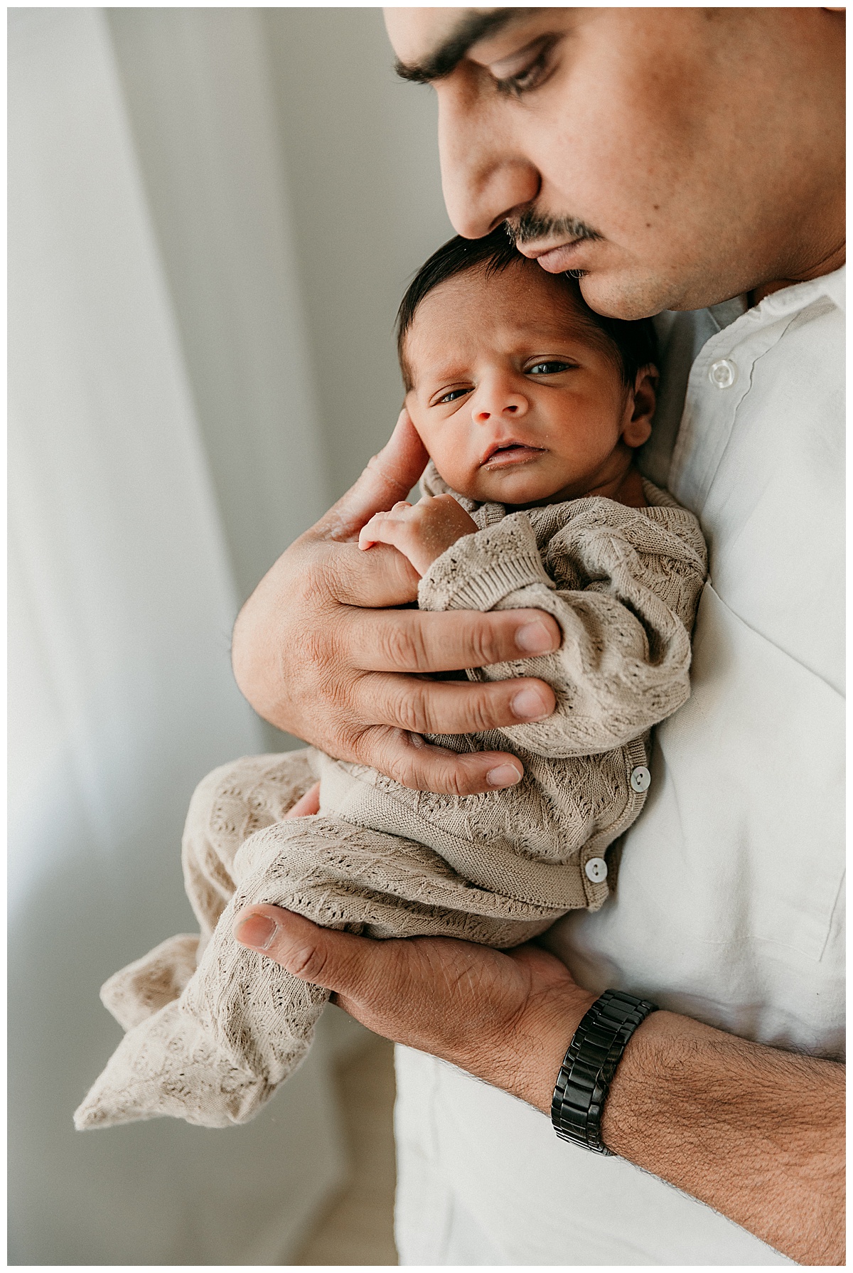 Baby sits in Dad's arms for Virginia Newborn Photographer