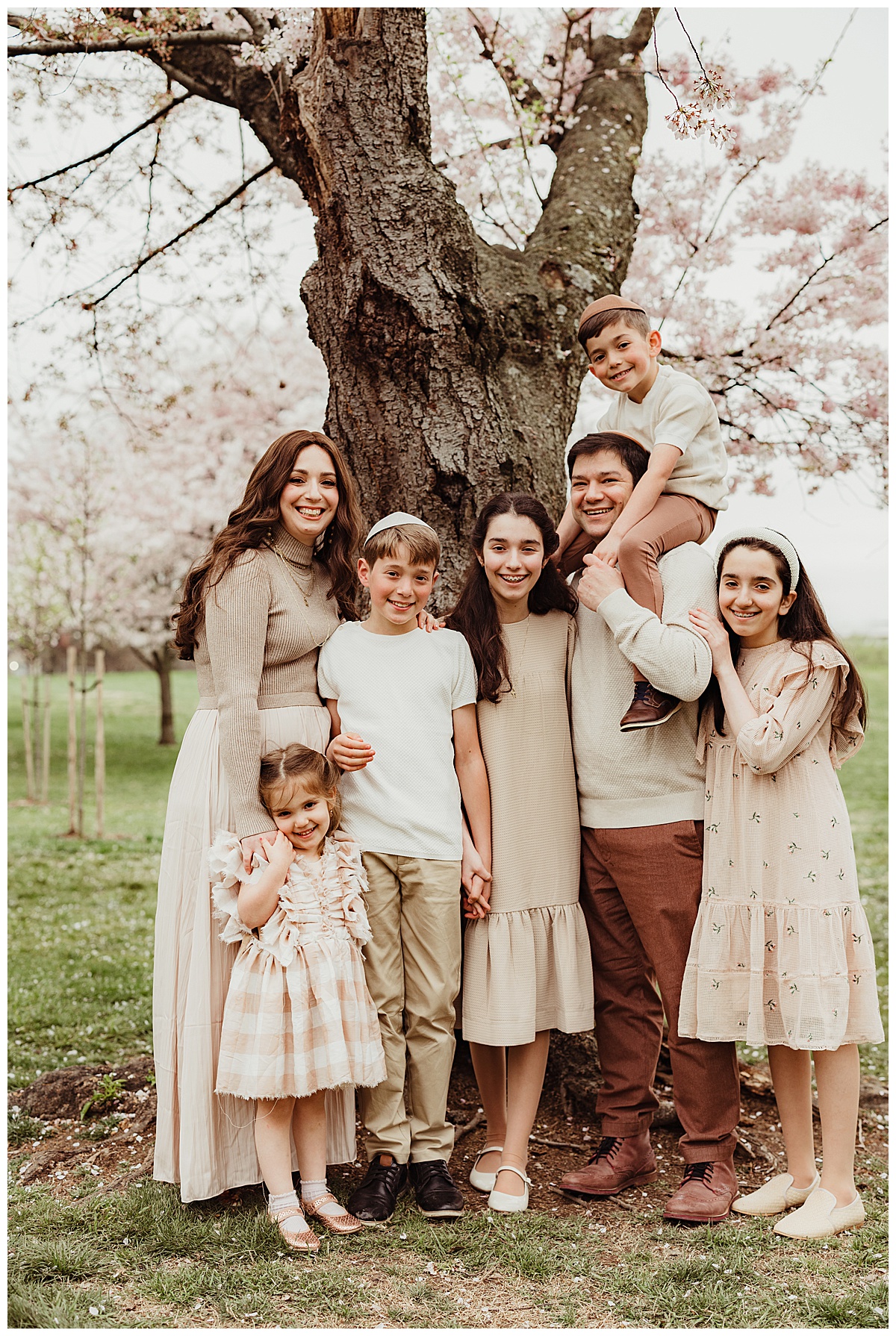 Gorgeous family stand close together for Cherry Blossom Family Photos