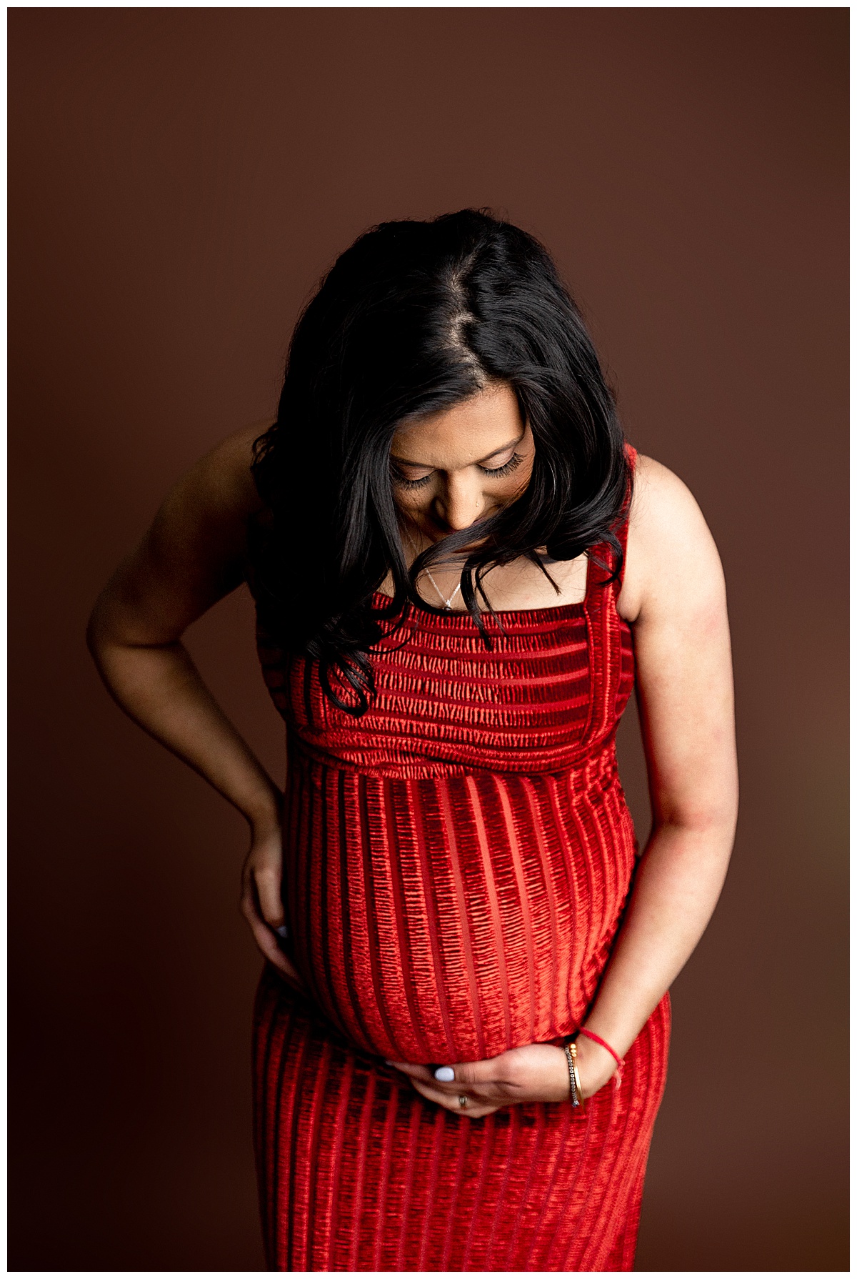 Mother looks down at pregnant belly for Norma Fayak Photography