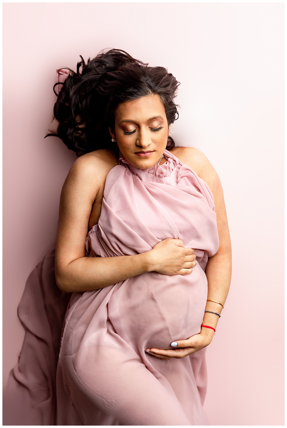 Woman holds baby bump for Norma Fayak Photography