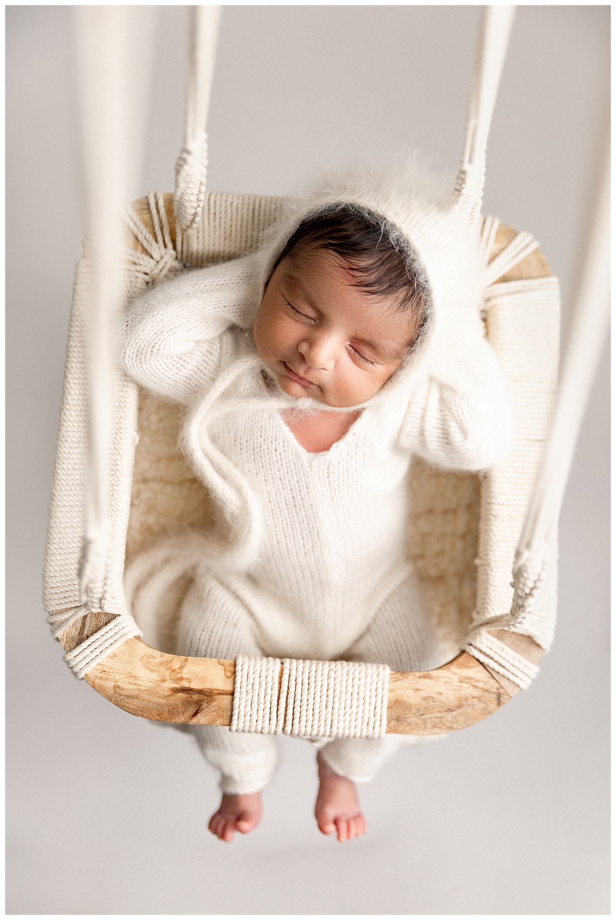 Baby boy sits in swing for Virginia Newborn Photographer