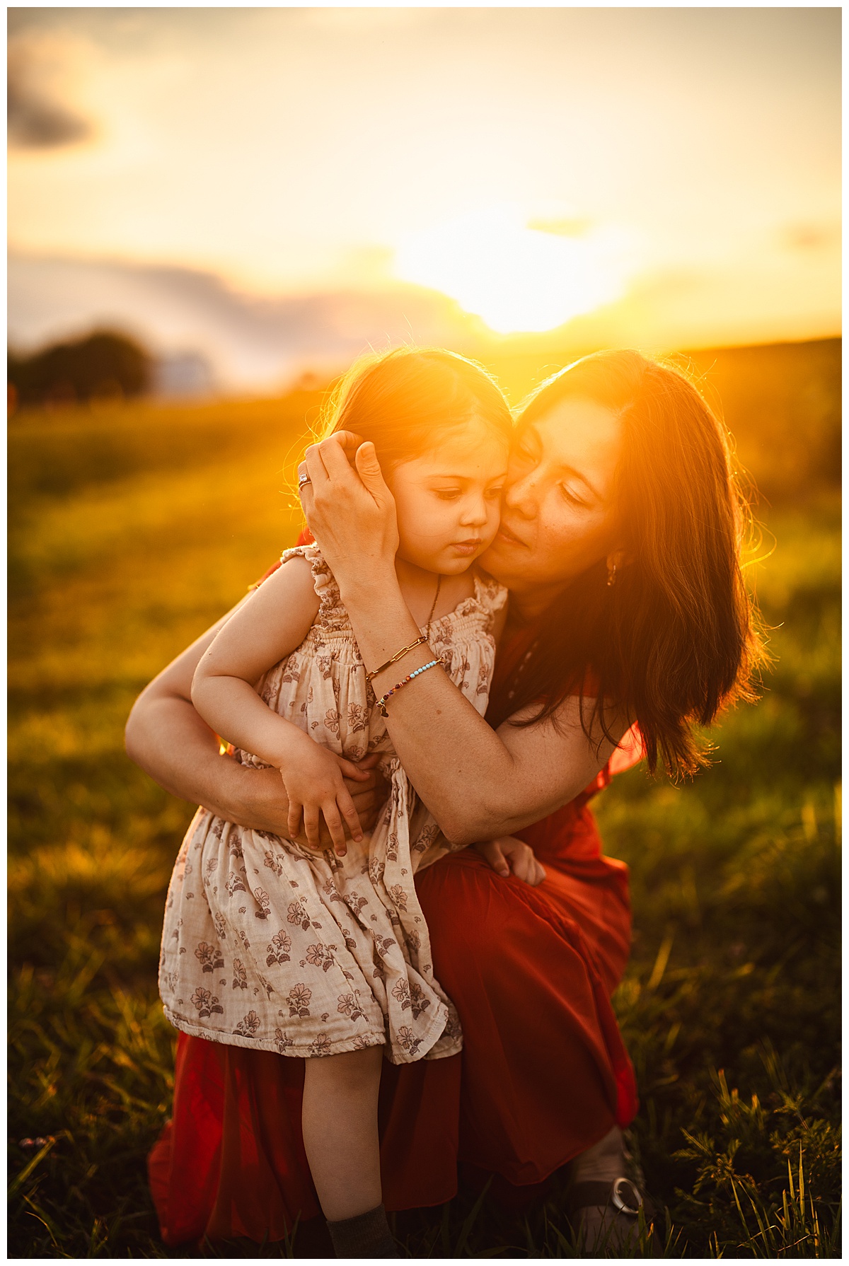 Mom and young girl hug one another for Sunflower Field Family Photos