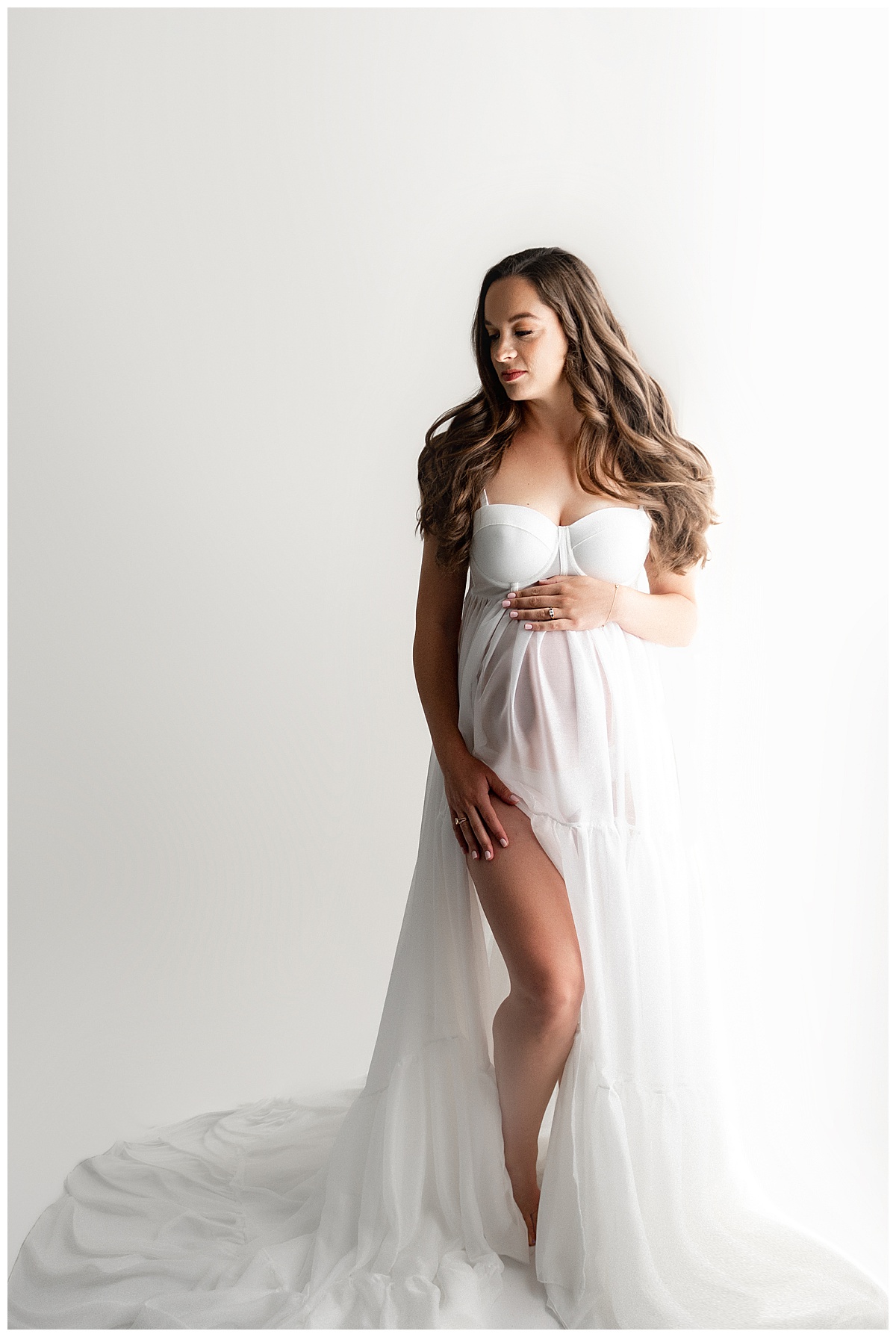 Mom has stunning Hair & Makeup for maternity session wearing a beautiful white gown