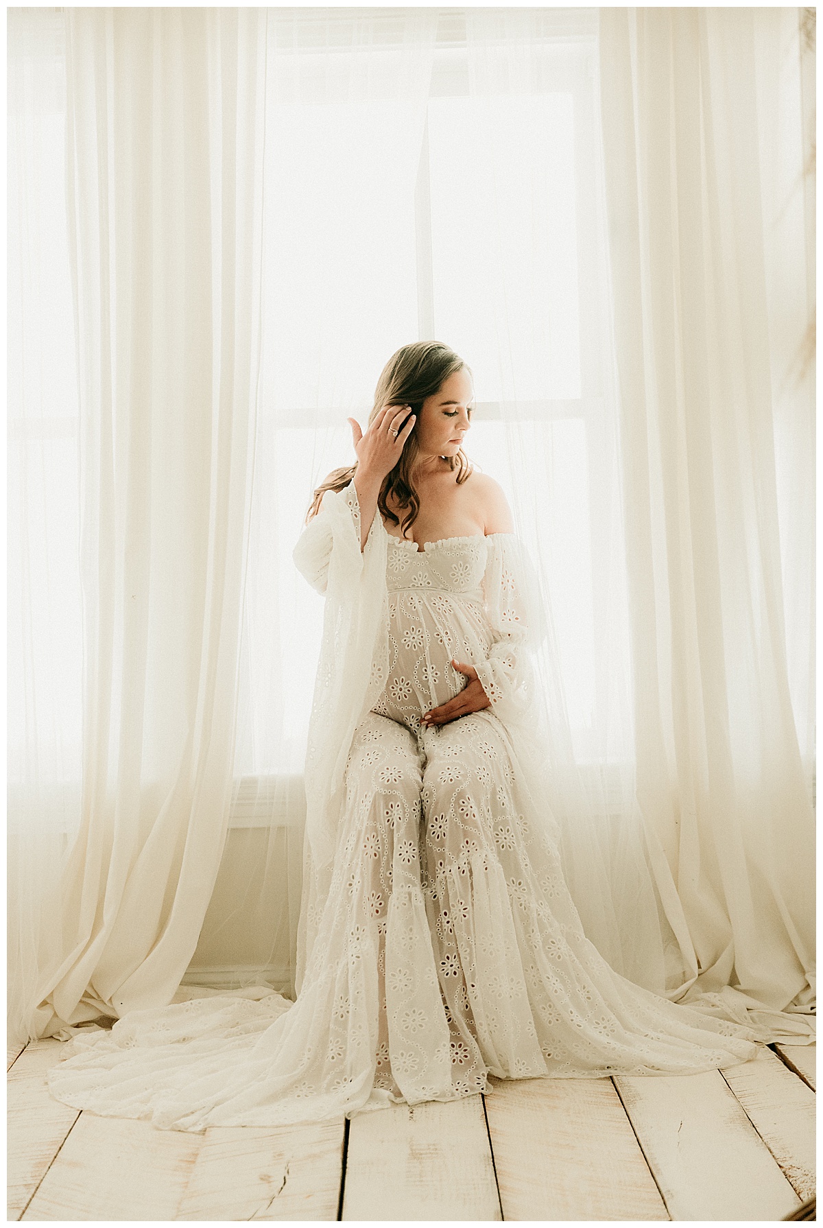 Adult holds pregnant belly while wearing gorgeous white gown for Virginia Maternity Photographer