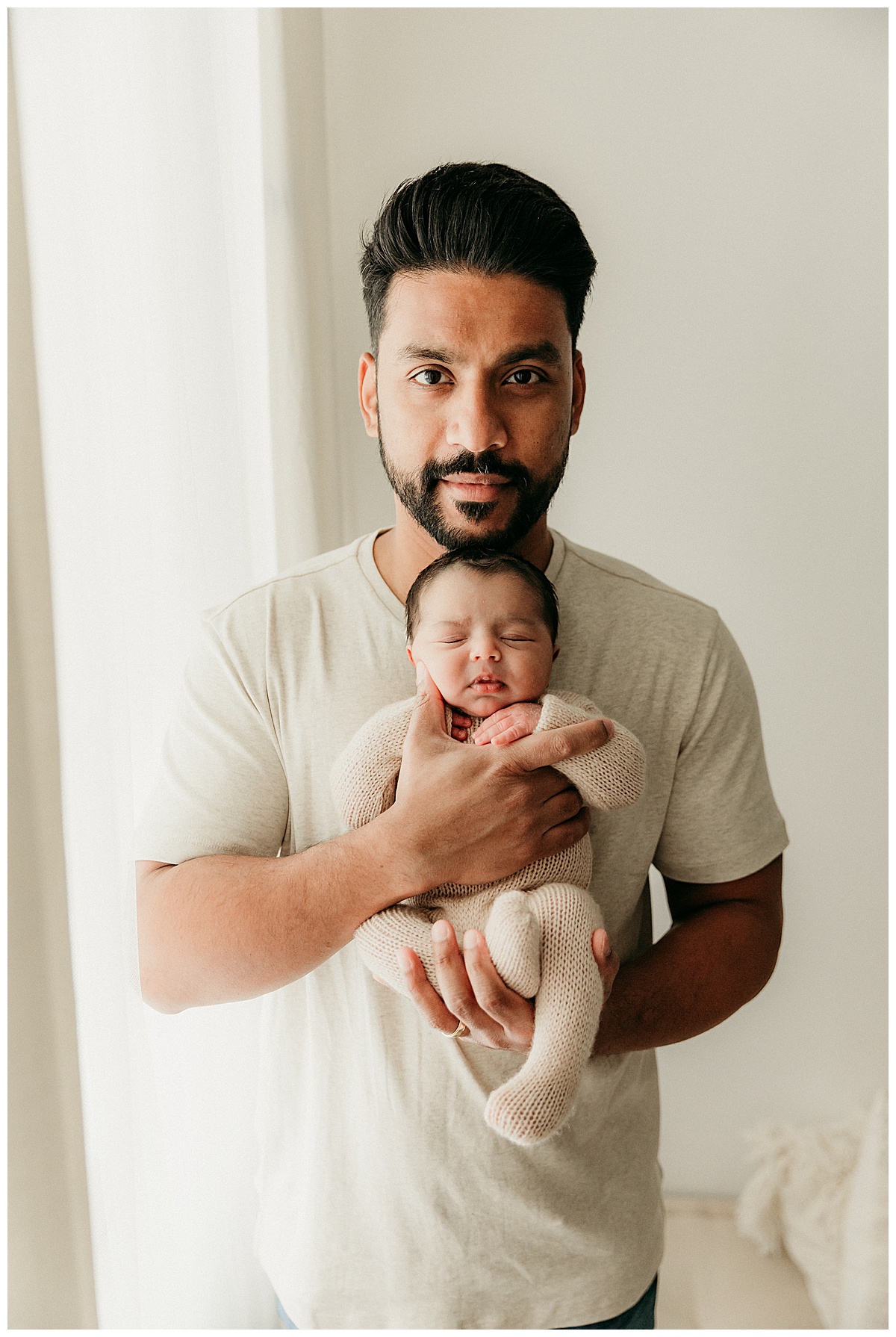 Dad holds baby close for a Successful Newborn Session With Your Toddler