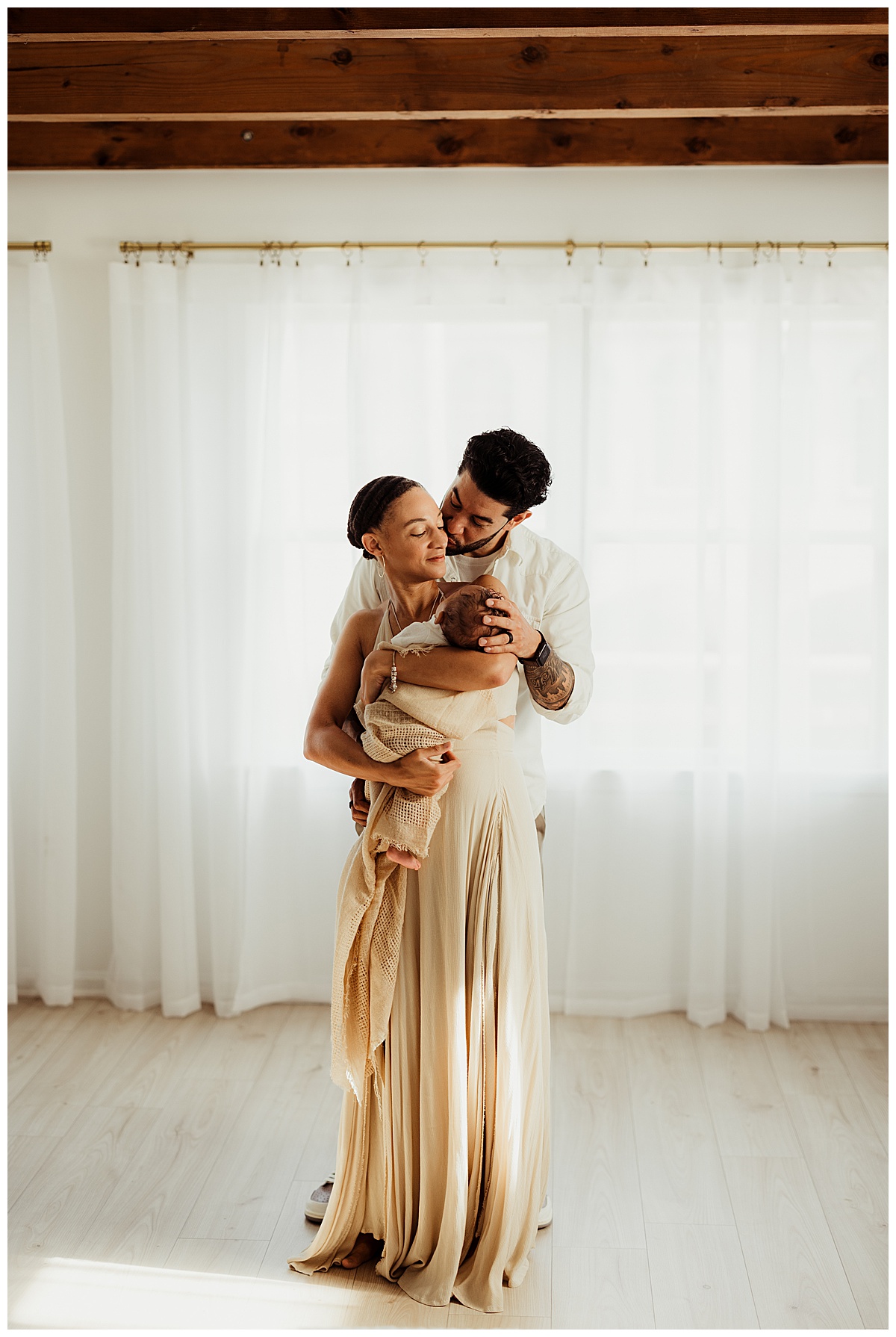 Mom and dad hold their baby close during their Lifestyle Newborn Session