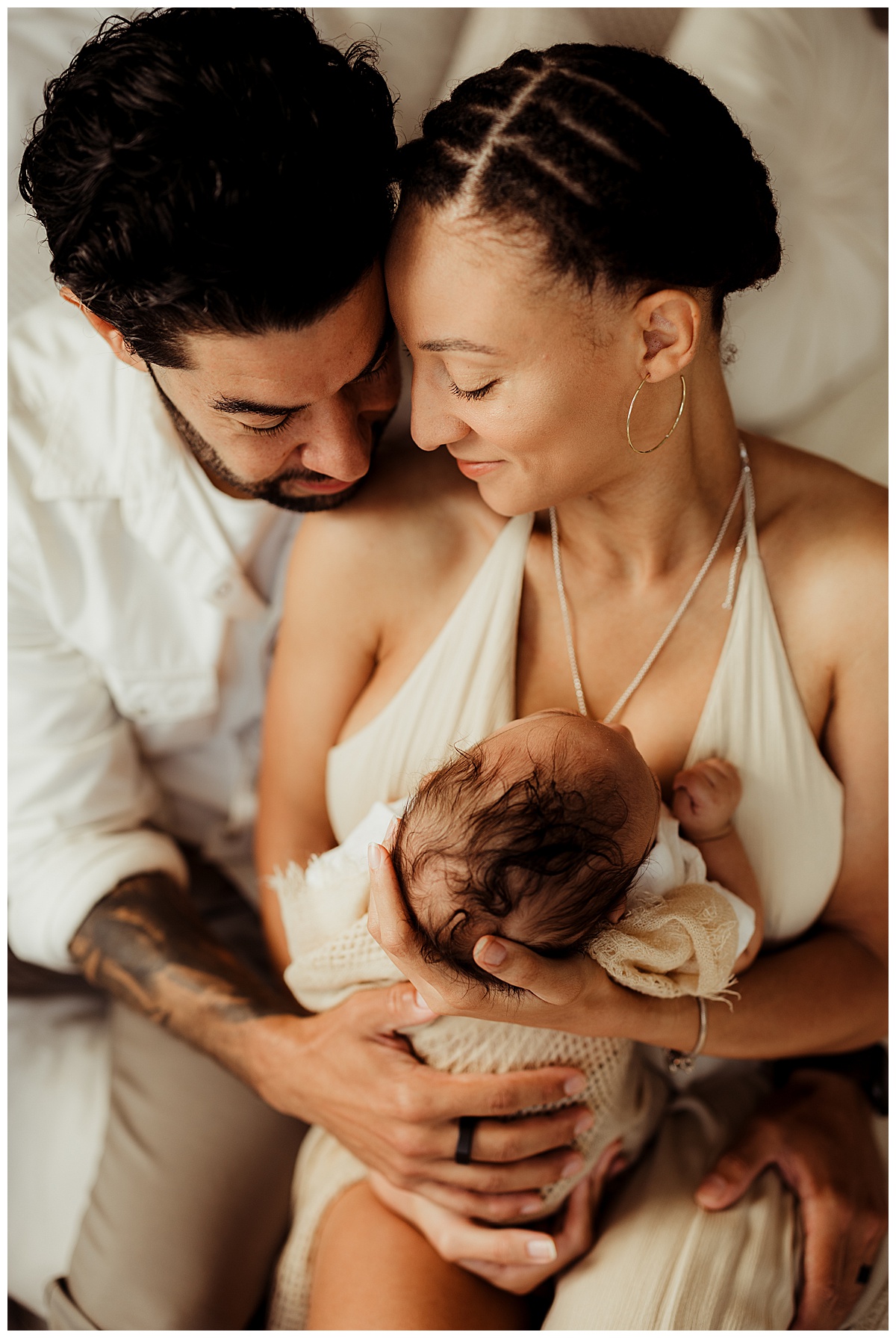 Mom and dad cuddle in with their baby for Lifestyle Newborn Session