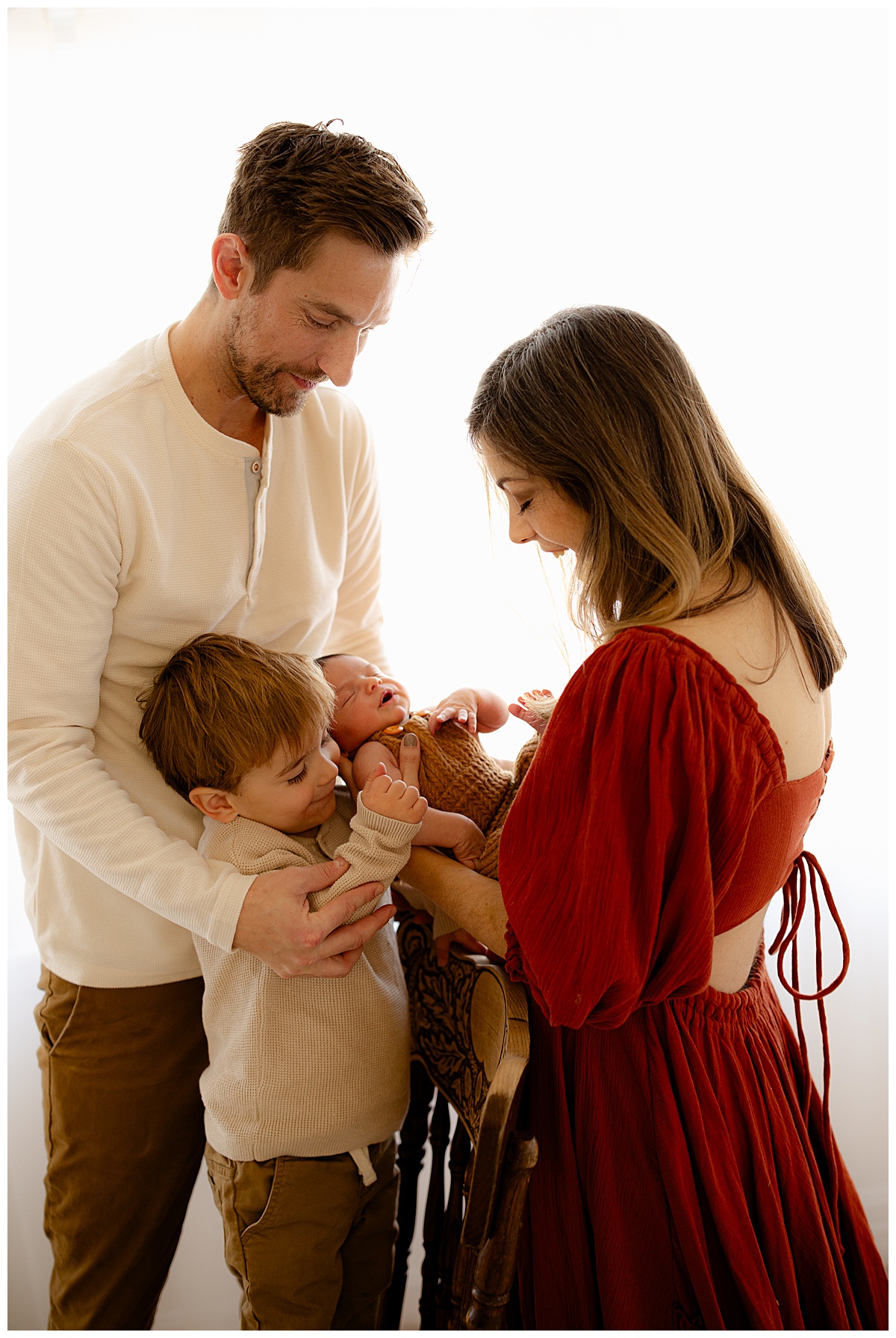 Parents smile at their baby using must-have Gear for Newborn Photography