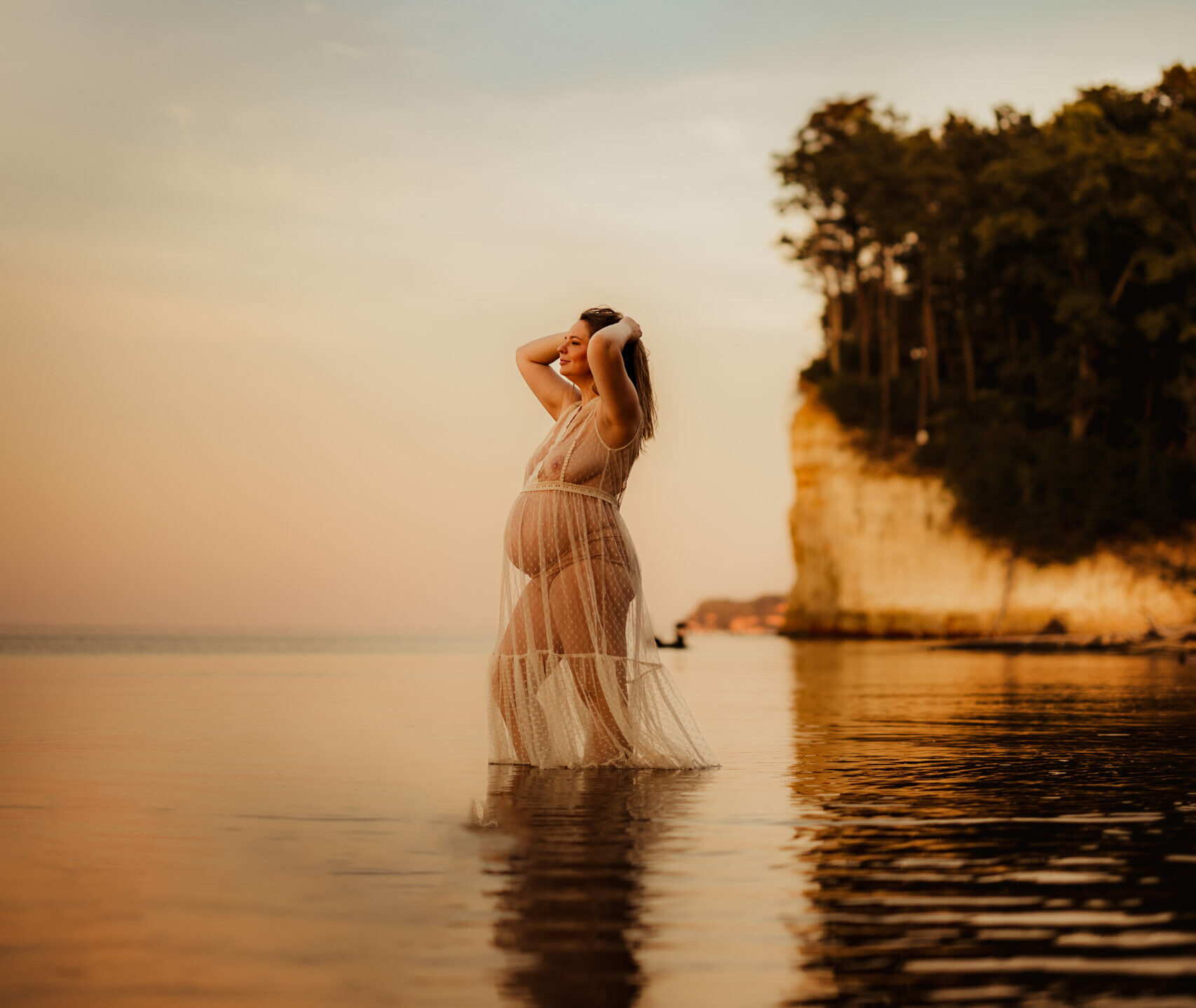 pregnant woman near ocean by Norma Fayak Photography