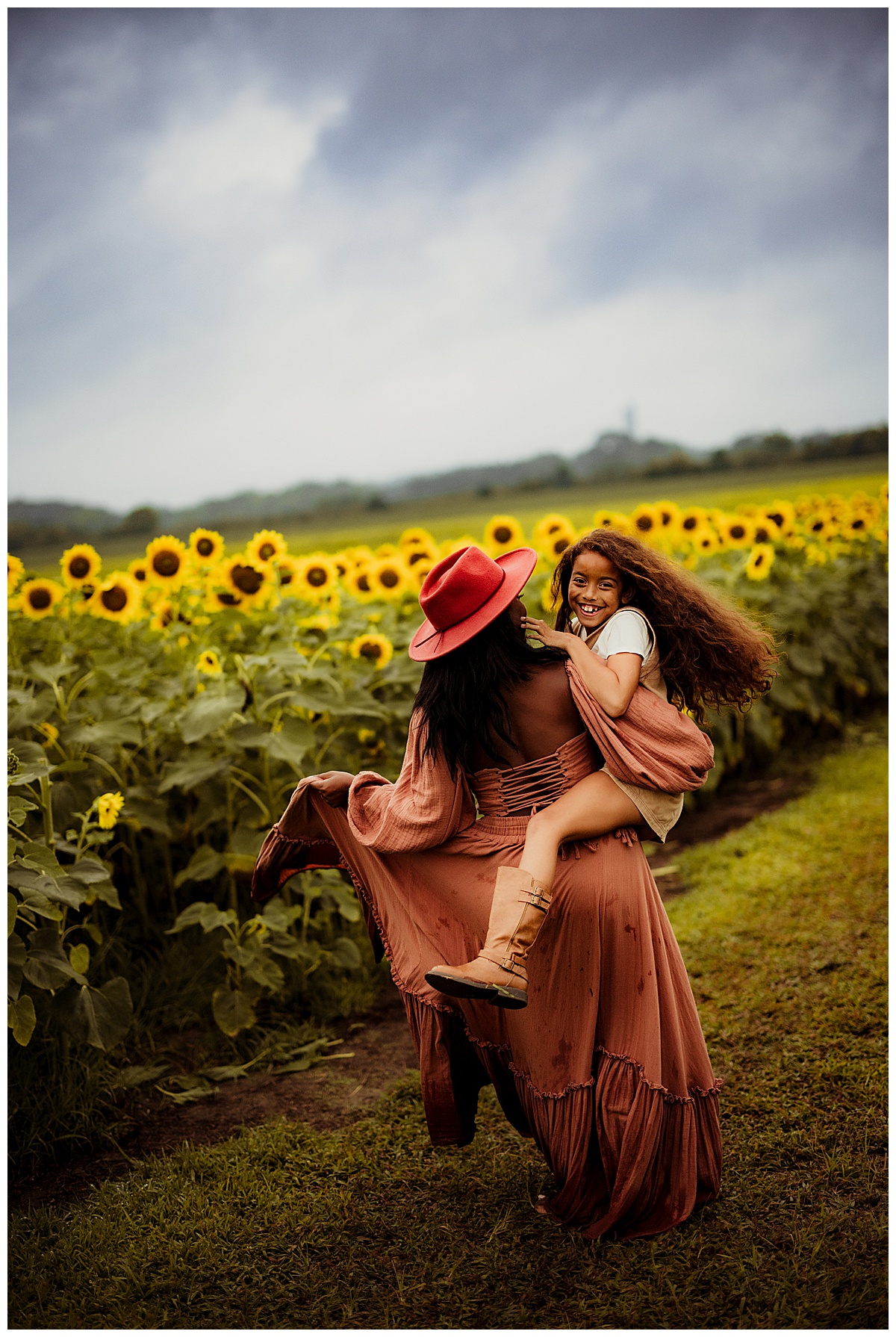 Mom and daughter walk together during their sunflower photoshoot