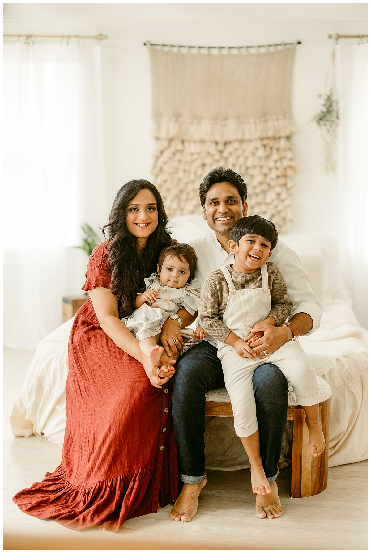 Family smiles together on the bed for Norma Fayak Photography