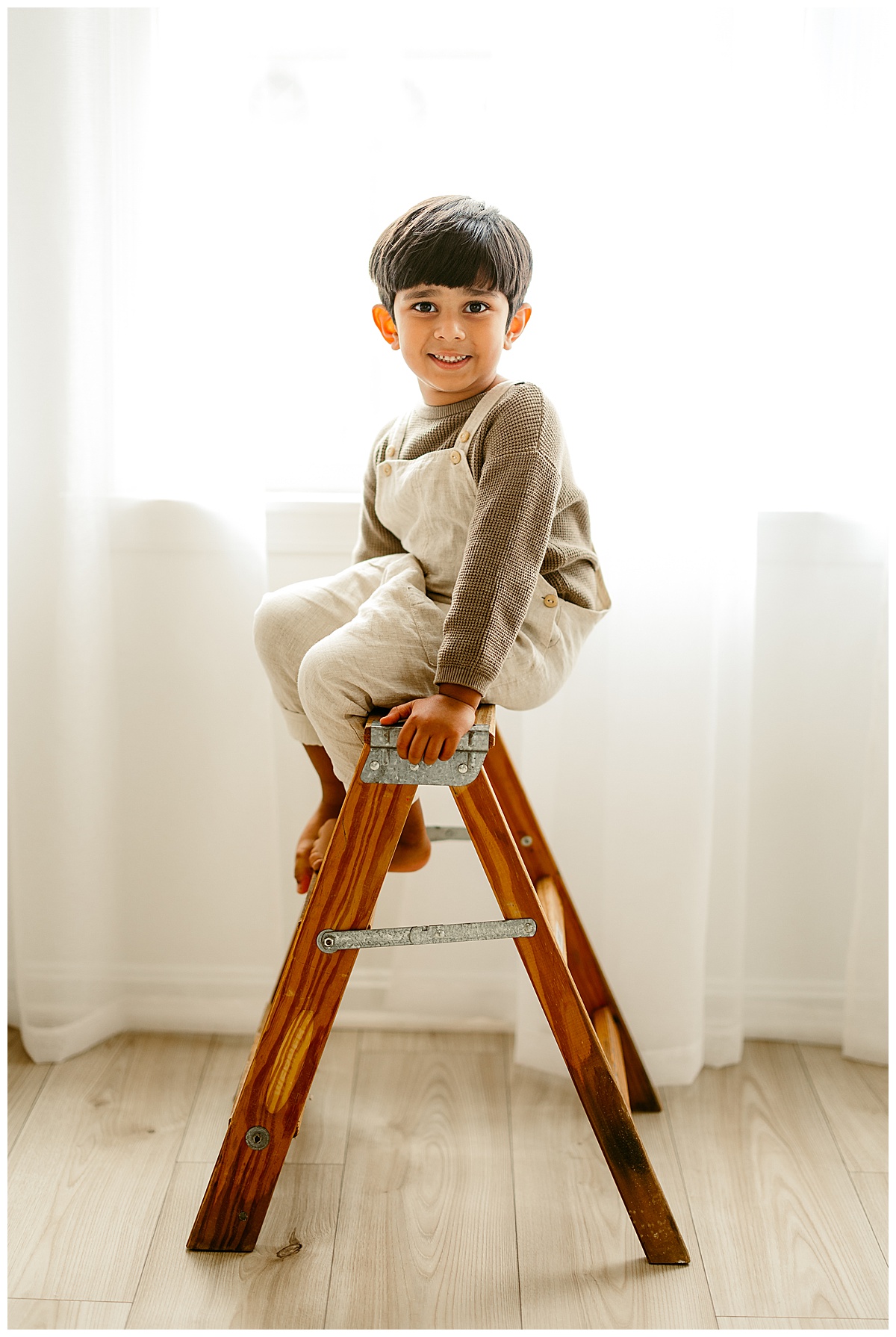 Young boy sits on a stool for Norma Fayak Photography