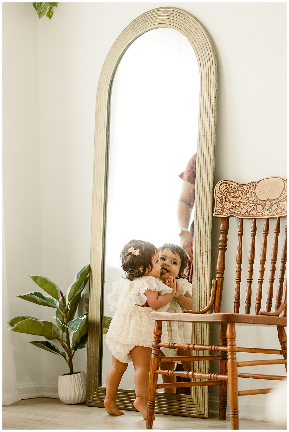Young girl plays in front of the mirror during their Unposed Lifestyle Shoot