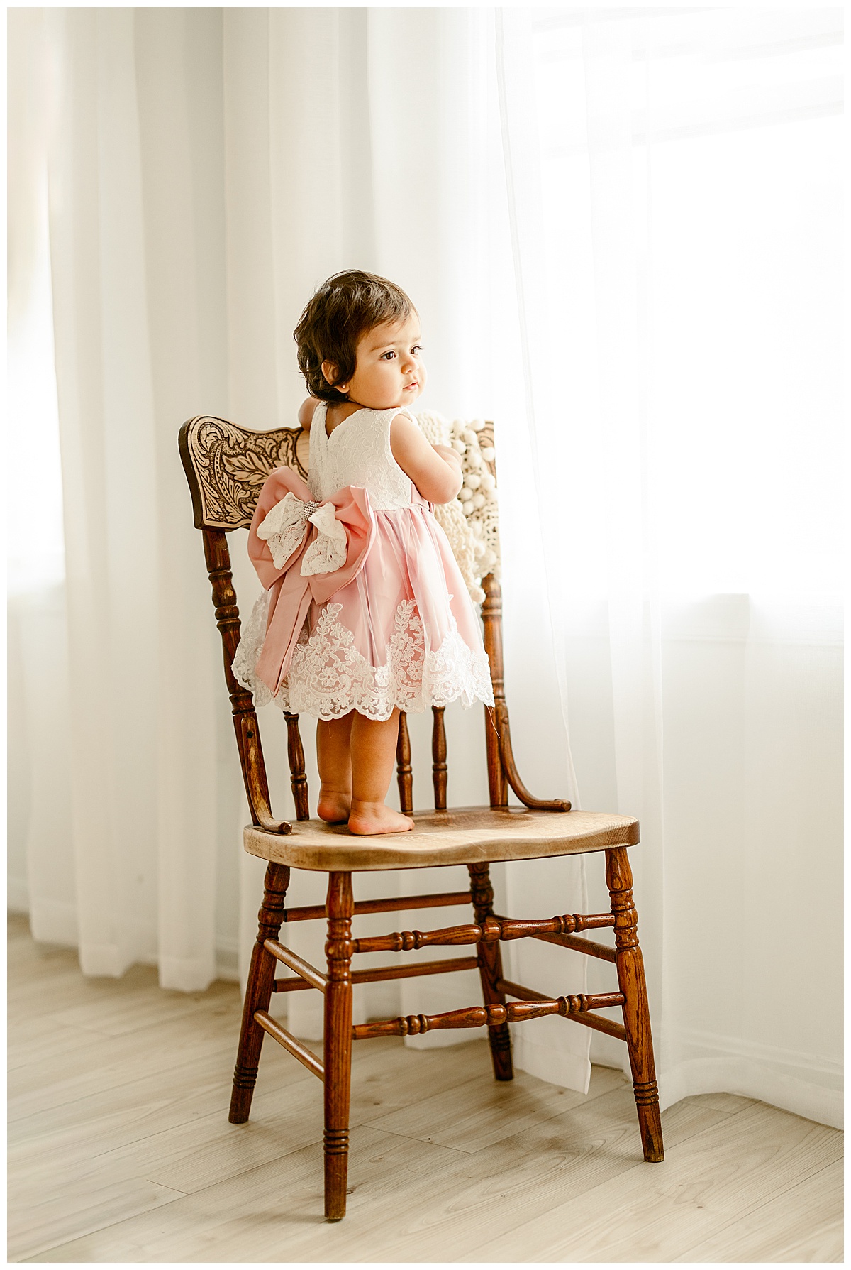 Baby girl stands on a chair during their Unposed Lifestyle Shoot