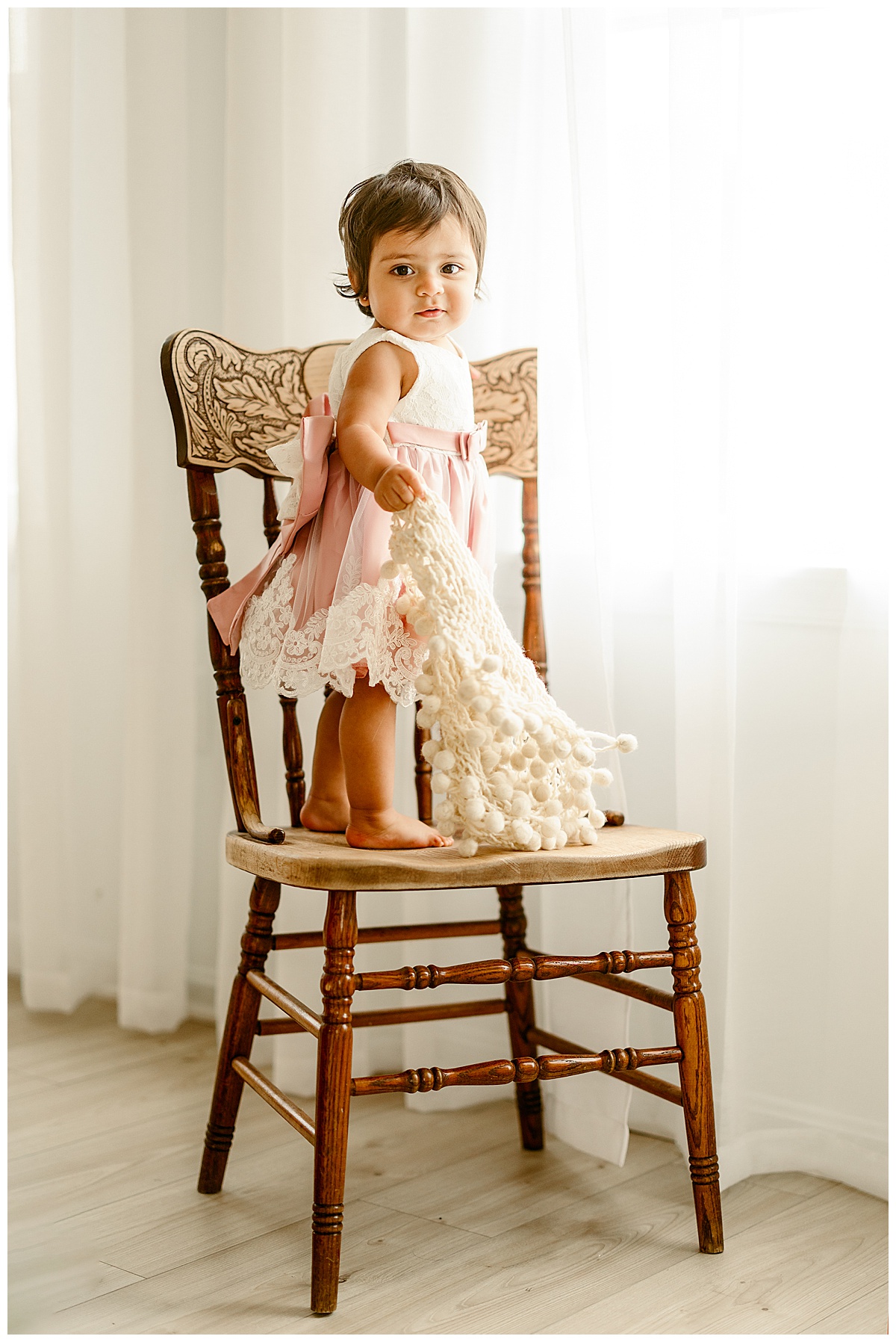 Baby girl stands on a chair for Virginia Family Photographer