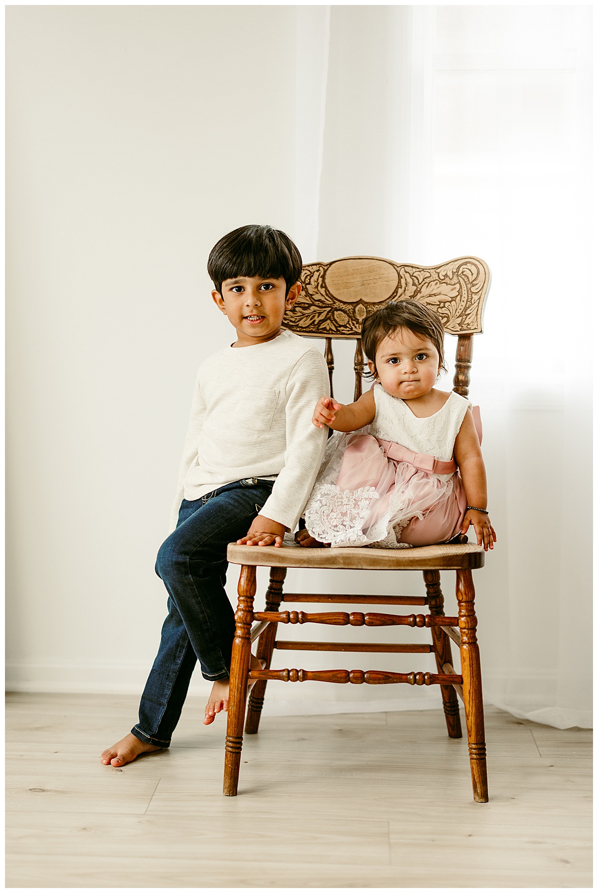 Siblings sit on a chair together for Norma Fayak Photography
