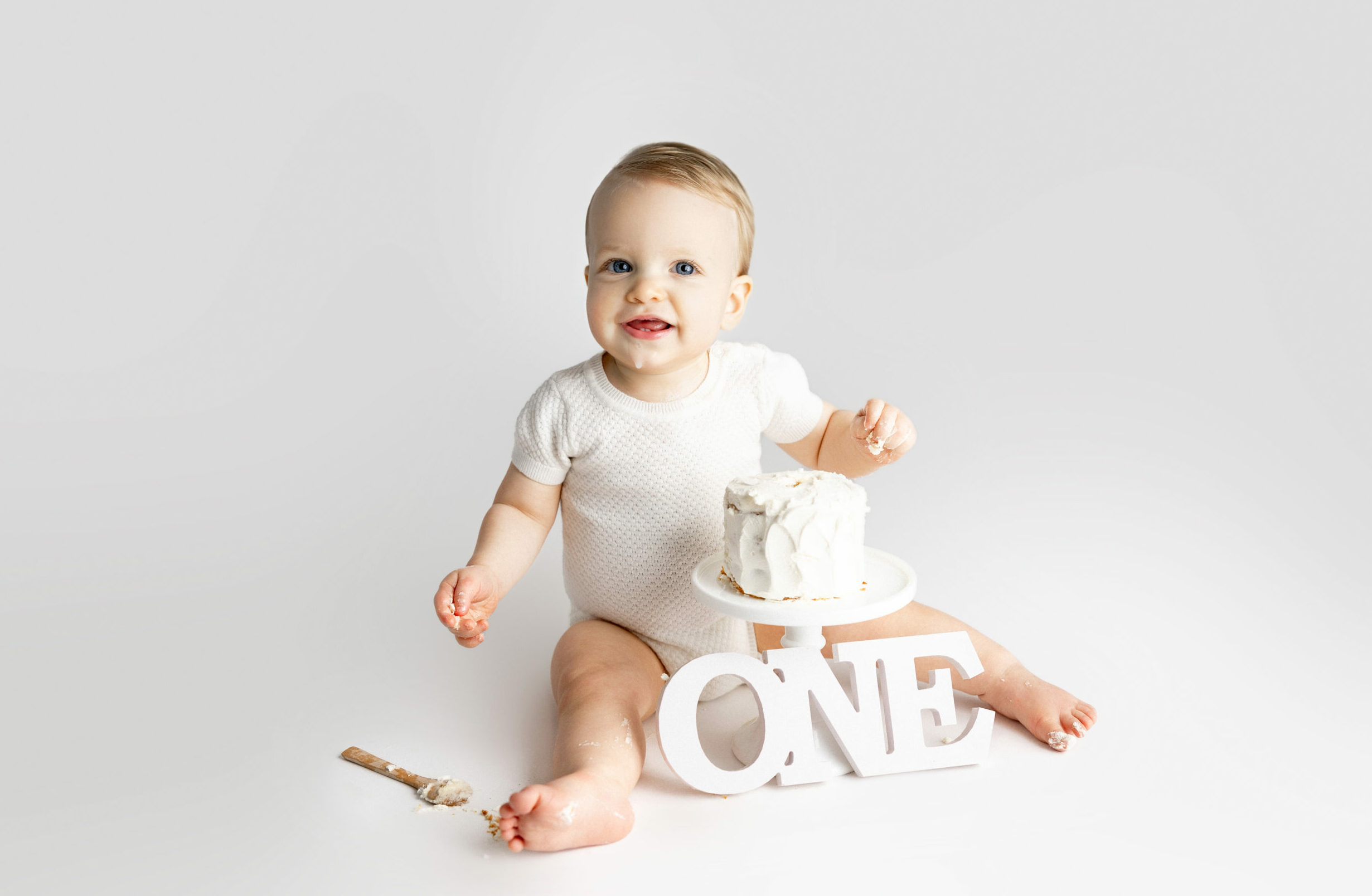 Young baby sits down and enjoy cakes for Norma Fayak Photography