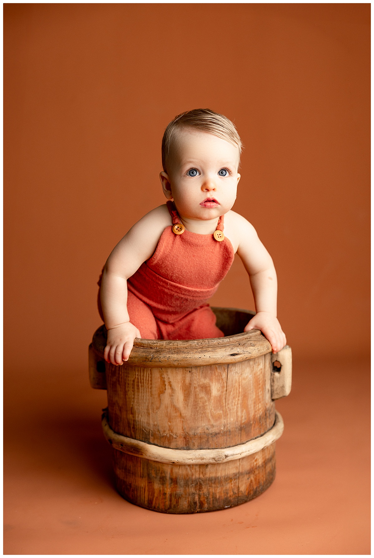 Young baby sits in a barrel for Virginia Newborn Photographer