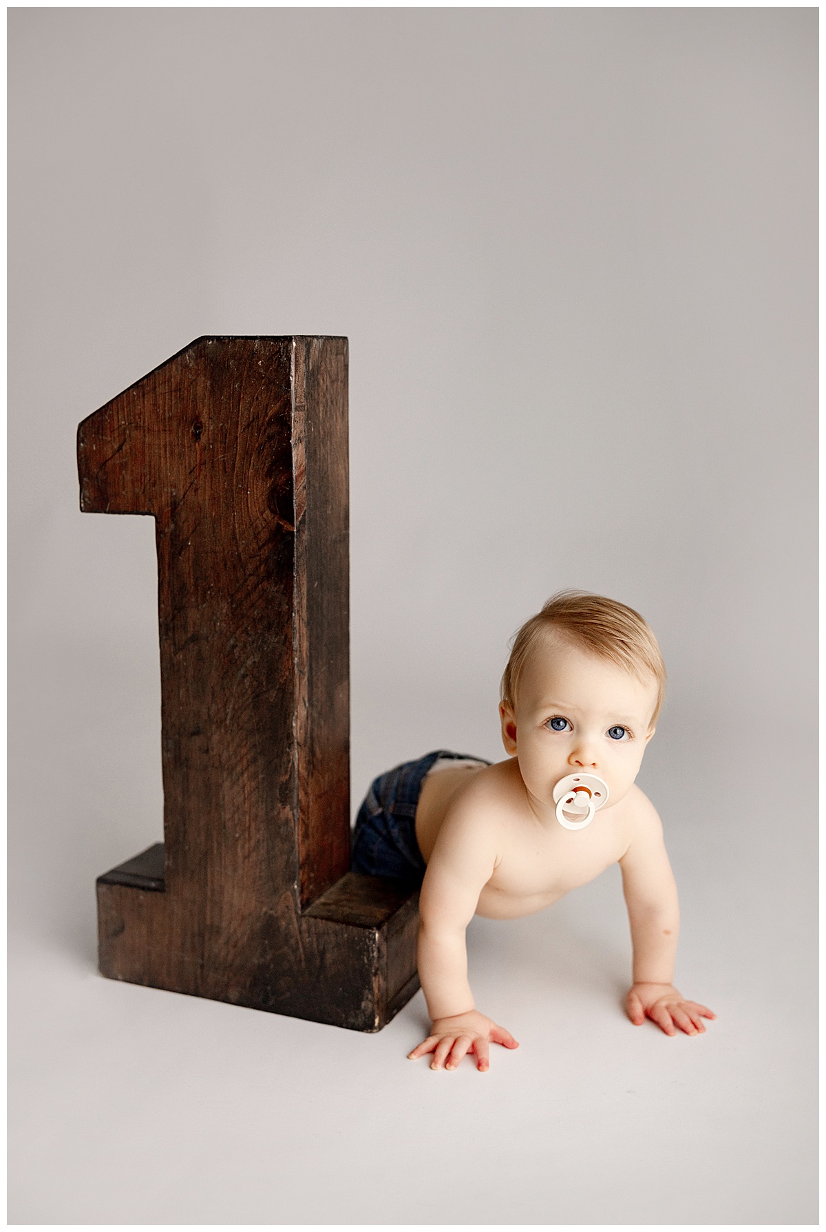 Little baby crawling by wooden number one for Virginia Newborn Photographer