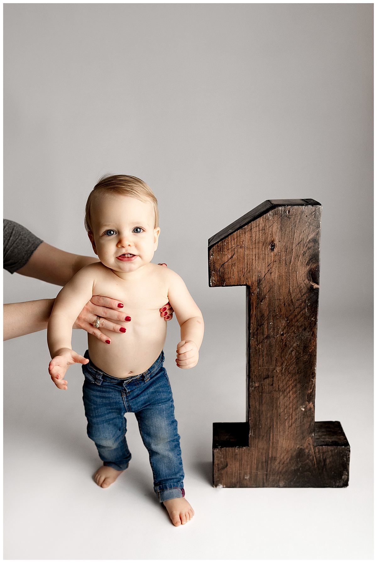 Baby stands by wooden number one for Norma Fayak Photography