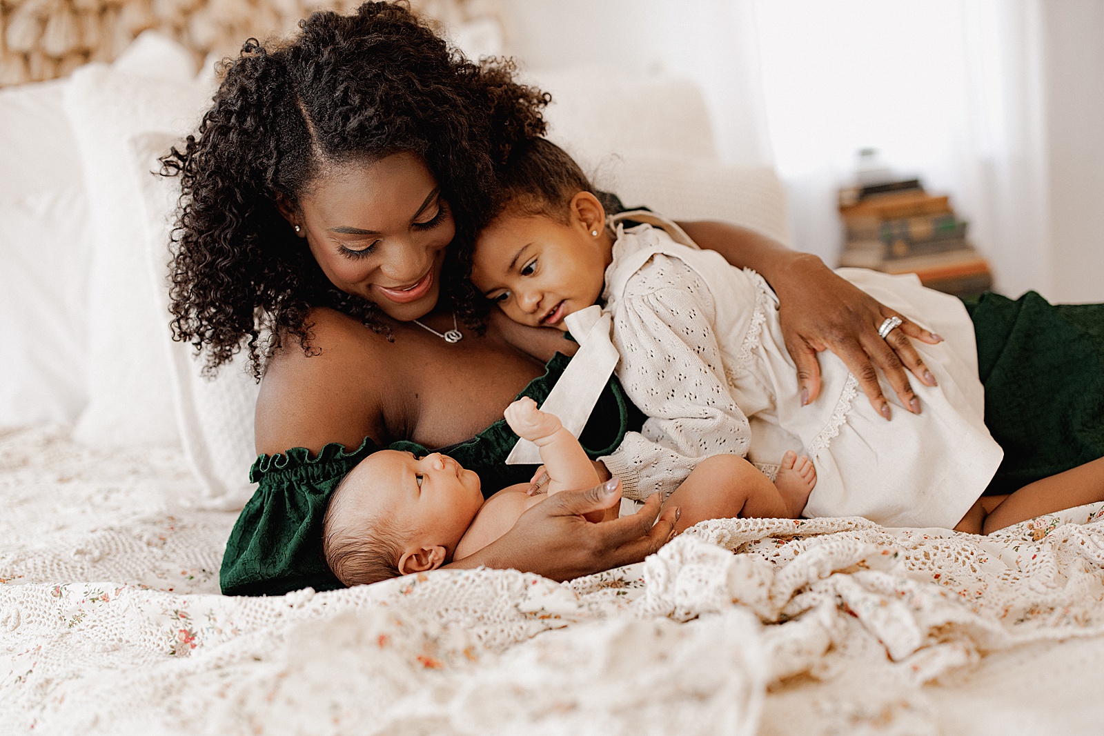 Mom cuddles kids together during Lifestyle Newborn Session